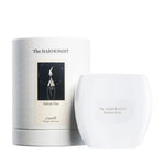 The Harmonist Velvet Fire candle with white glass container and matching cylindrical packaging.